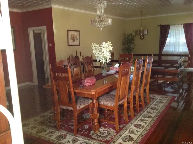 a dining room with furniture a chandelier and wooden floor