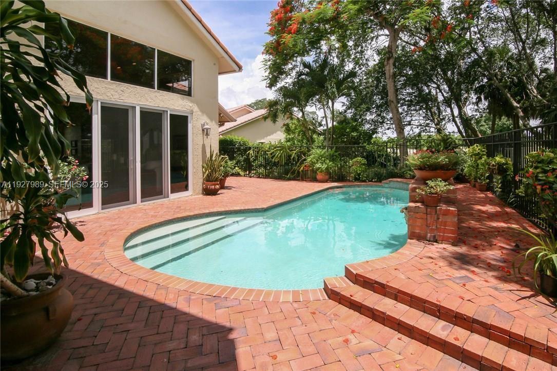 7820 Northwest 83rd Street Tamarac, FL 33321 - Photo 2 of 3 a view of a white house with a yard potted plants and large tree
