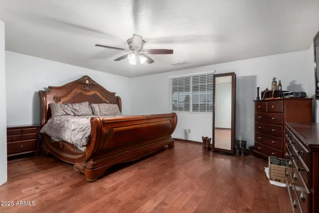 a bedroom with a bed and wooden floor