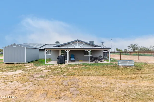a white house that has a big yard and a large tree