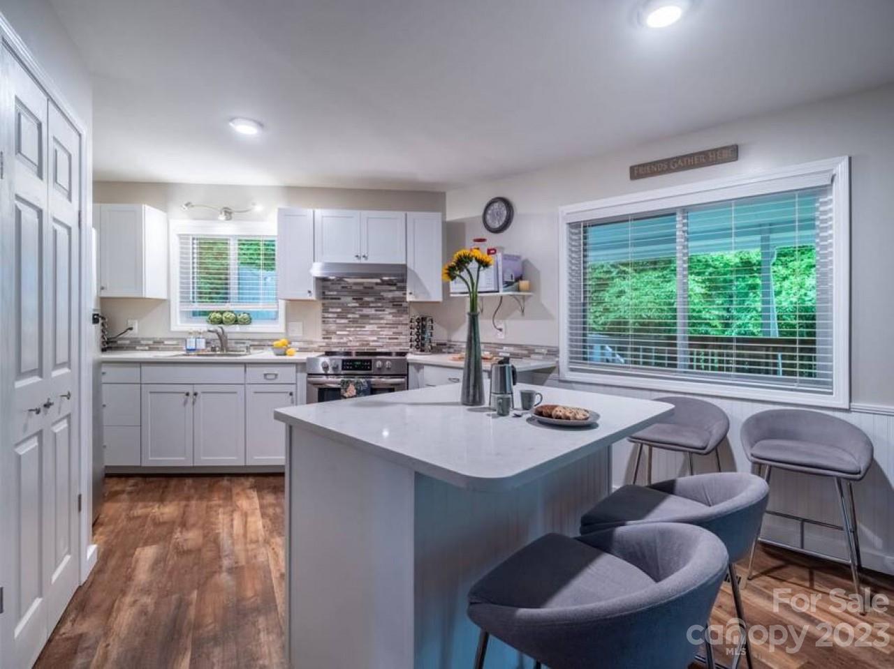 180 Hemlock Loop Maggie Valley, NC 28751 - Photo 12 of 28 a kitchen with sink refrigerator dining table and chairs