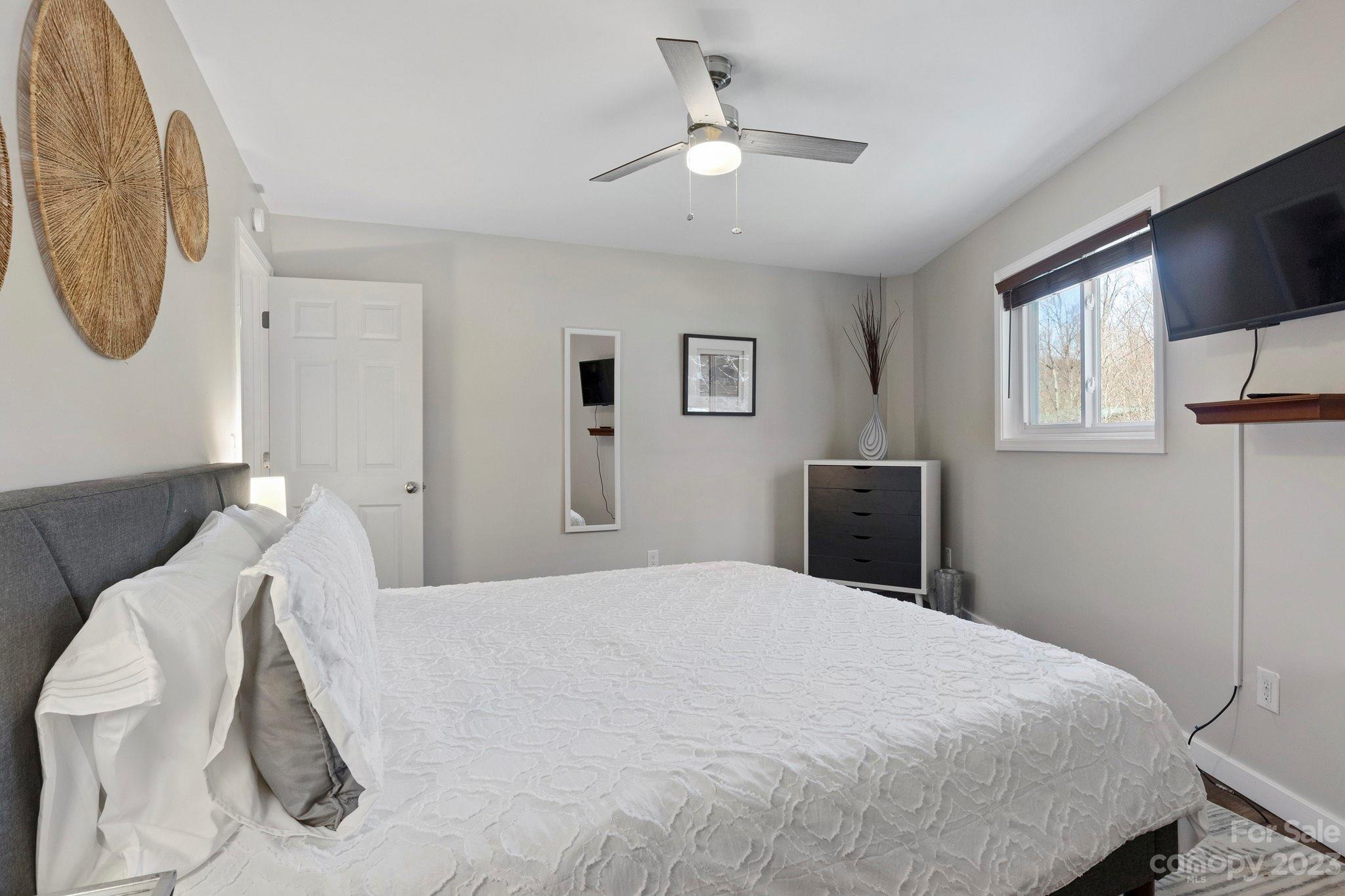 180 Hemlock Loop Maggie Valley, NC 28751 - Photo 17 of 28 a bedroom with a bed mirror and window