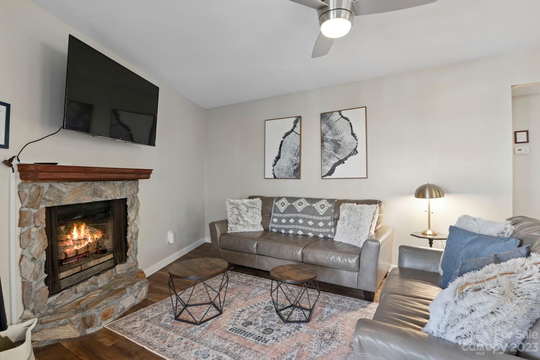 180 Hemlock Loop Maggie Valley, NC 28751 - Photo 6 of 28 a living room with furniture a flat screen tv and a fireplace