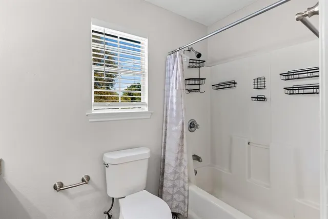 a white toilet sitting next to a bath tub shower