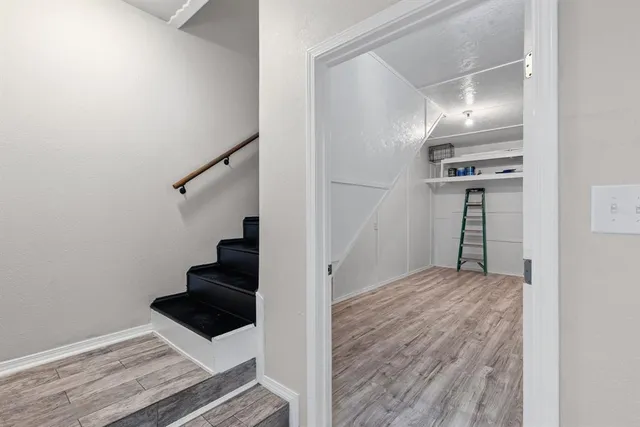 a view of a hallway with wooden floor and entryway