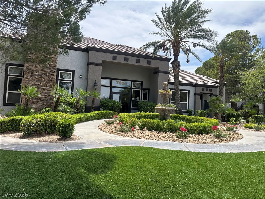 A graceful building exterior boasts a central water feature, surrounded by verdant landscaping.