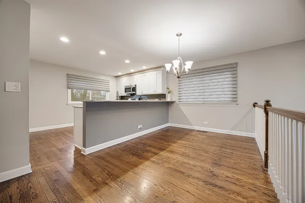 a kitchen with stainless steel appliances granite countertop a sink a stove a refrigerator and cabinets with wooden floor