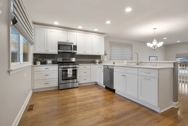 a kitchen with a refrigerator sink and cabinets