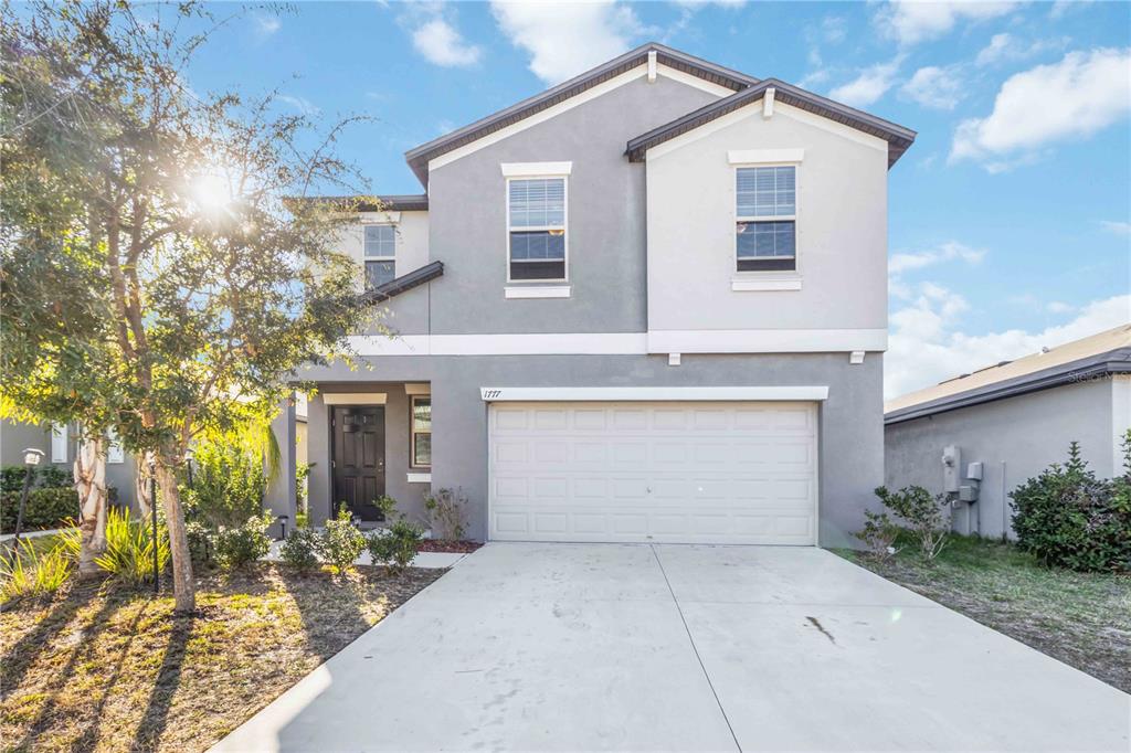 1777 Fred Ives Street Ruskin, FL 33570 - Photo 2 of 35 a front view of a house with a yard and garage