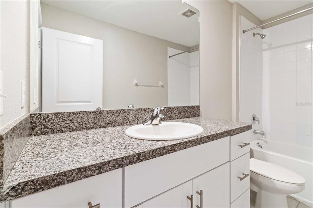 1777 Fred Ives Street Ruskin, FL 33570 - Photo 22 of 35 a bathroom with a granite countertop sink and a mirror