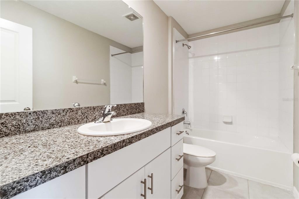 1777 Fred Ives Street Ruskin, FL 33570 - Photo 23 of 35 a bathroom with a granite countertop sink a toilet and a shower