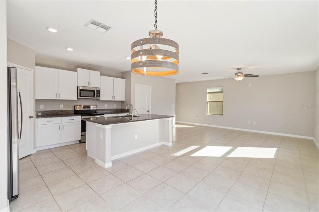 1777 Fred Ives Street Ruskin, FL 33570 - Photo 8 of 35 a kitchen with stainless steel appliances granite countertop a stove a sink and a refrigerator