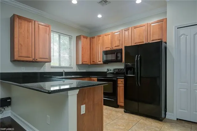 a kitchen with kitchen island granite countertop a refrigerator stove and sink