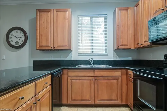 a kitchen with granite countertop cabinets stainless steel appliances and a window