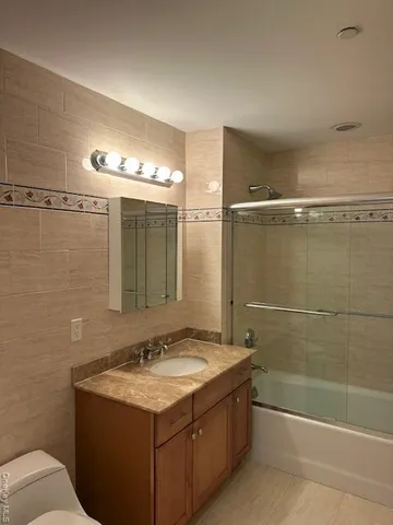 a bathroom with a granite countertop sink a toilet and shower