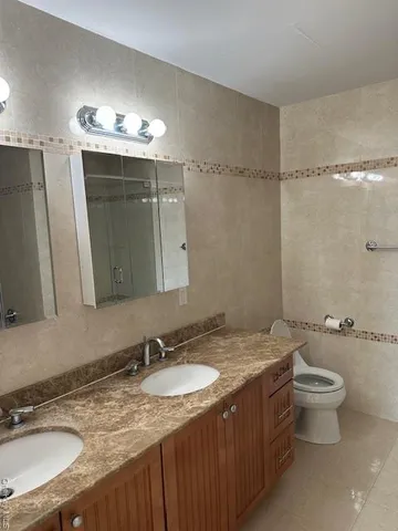a bathroom with a granite countertop sink toilet a mirror a vanity and shower
