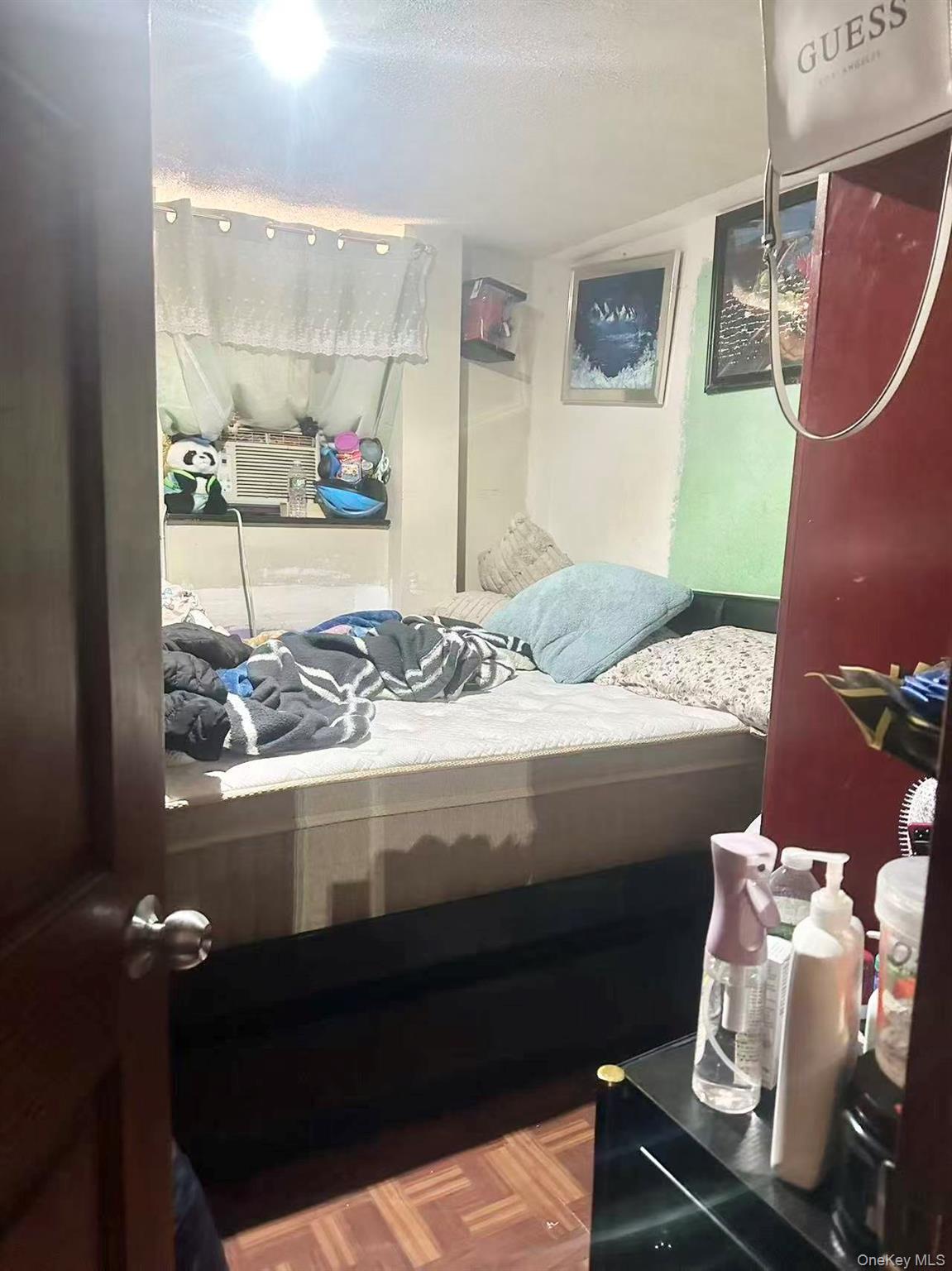 56-22 Van Cleef Street Queens, NY 11368 - Photo 4 of 9 a bedroom with a bed and dresser with mirror