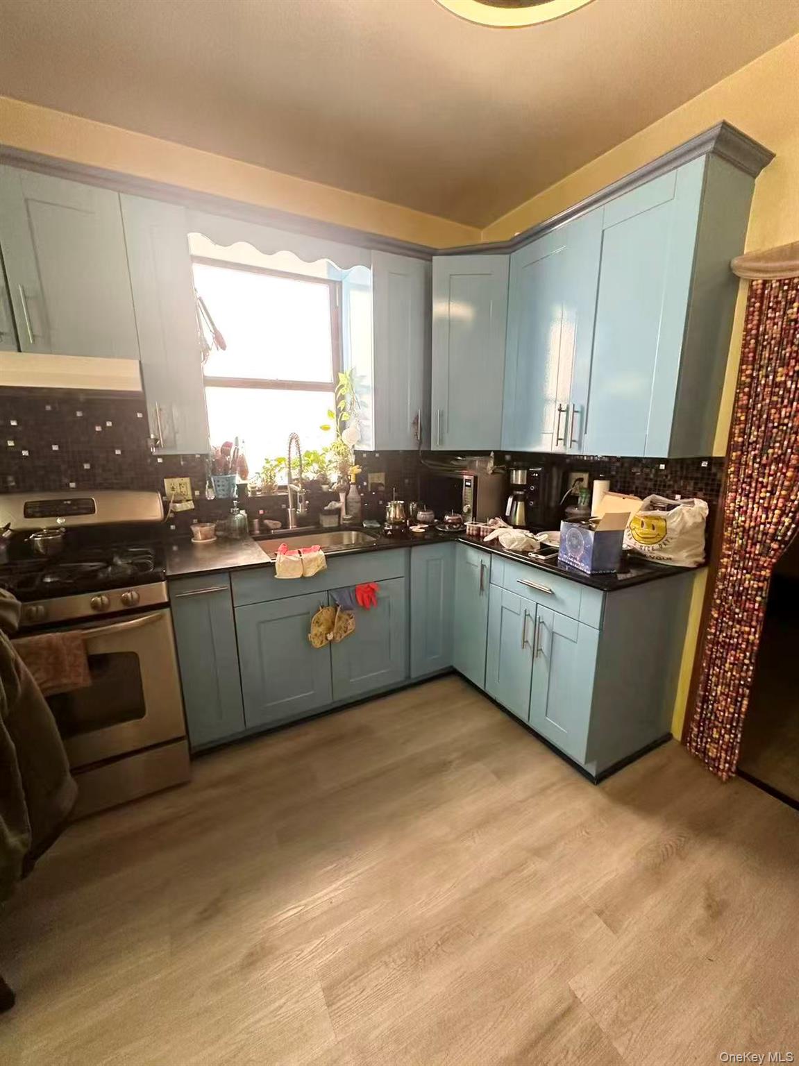 56-22 Van Cleef Street Queens, NY 11368 - Photo 6 of 9 a kitchen with stainless steel appliances granite countertop a sink a stove a microwave a sink a refrigerator and cabinets