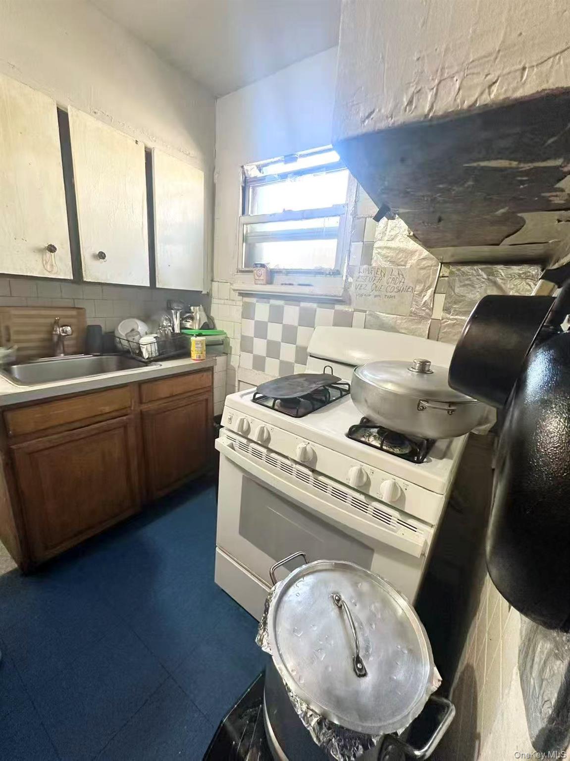 56-22 Van Cleef Street Queens, NY 11368 - Photo 7 of 9 a kitchen that has a sink and a stove