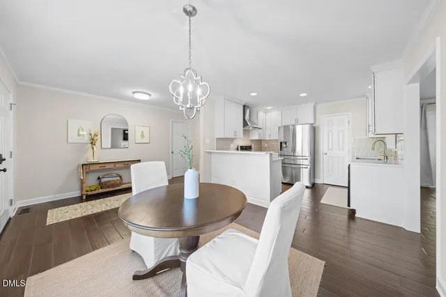 a living room with kitchen island dining table wooden floor and a dining table
