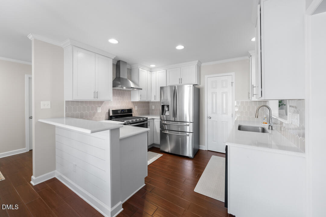 405 Latta Road Durham, NC 27712 - Photo 11 of 43 a kitchen with a refrigerator sink and white cabinets