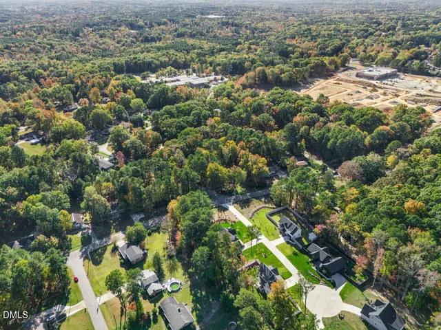 an aerial view of residential houses with outdoor space and trees