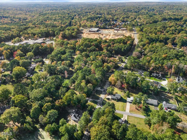 an aerial view of residential houses with outdoor space and trees