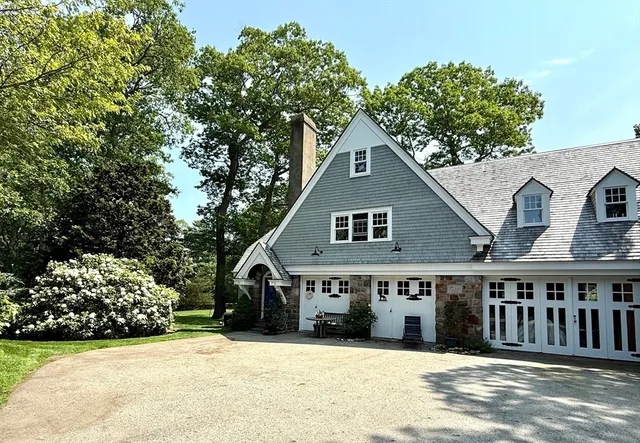 a front view of a house with a yard and trees