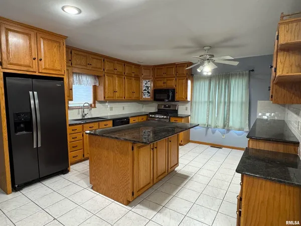 a kitchen with stainless steel appliances granite countertop a stove a sink and a refrigerator
