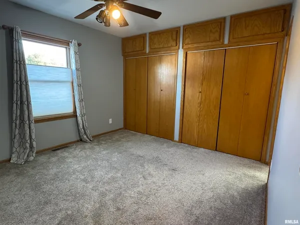 an empty room with closet and entryway
