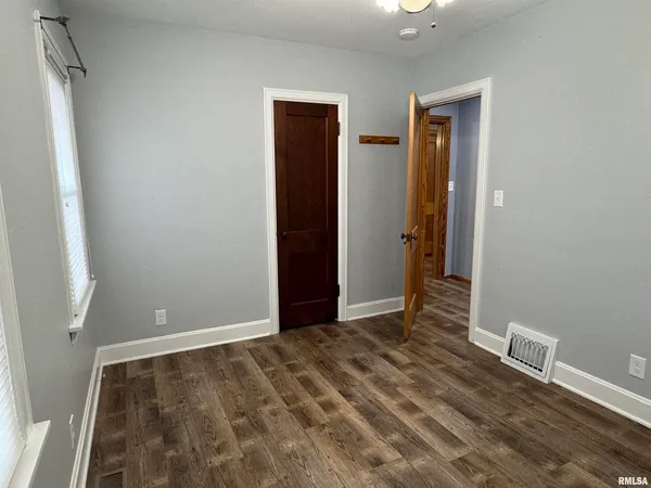 an empty room with wooden floor and closet