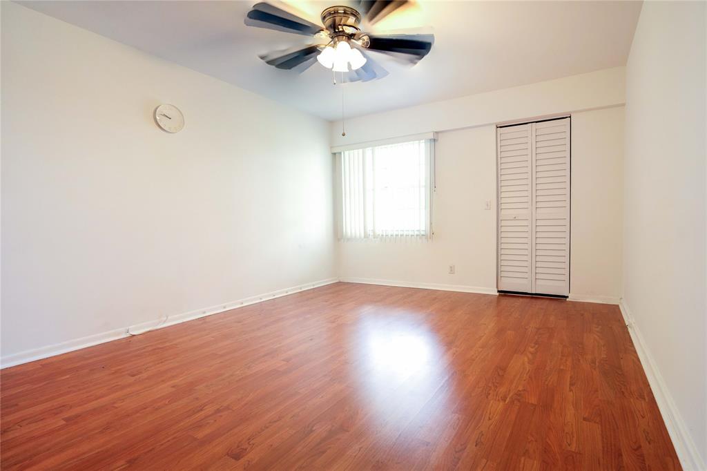300 Southwest 134th Way, Unit 402E Pembroke Pines, FL 33027 - Photo 14 of 46 an empty room with wooden floor chandelier fan and windows