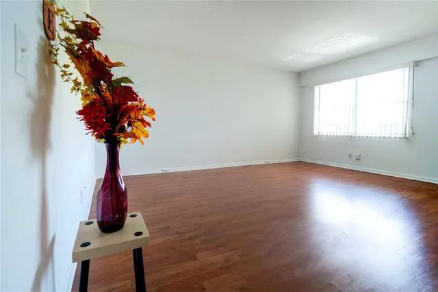 a room with lots of flowers and wooden floor
