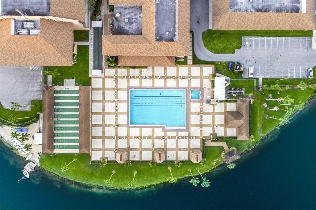 300 Southwest 134th Way, Unit 402E Pembroke Pines, FL 33027 - Photo 45 of 46 a view of a house with a swimming pool outdoor seating area and flowers