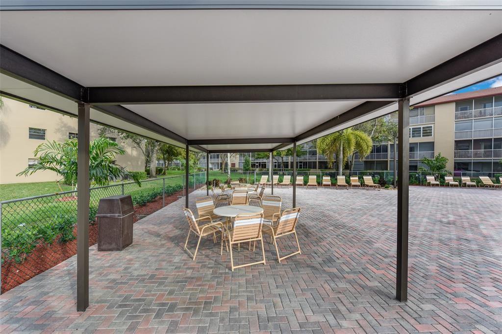 300 Southwest 134th Way, Unit 402E Pembroke Pines, FL 33027 - Photo 46 of 46 a patio with yard glass top table and chairs