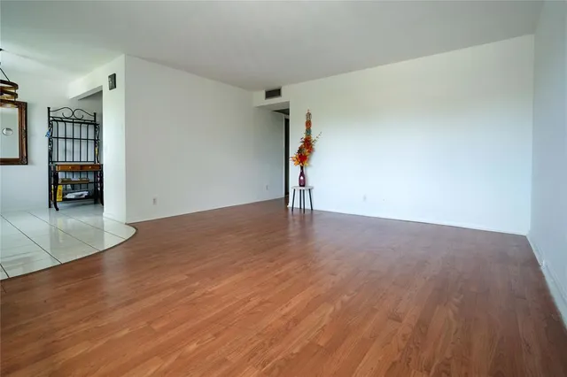 an empty room with wooden floor and a fireplace