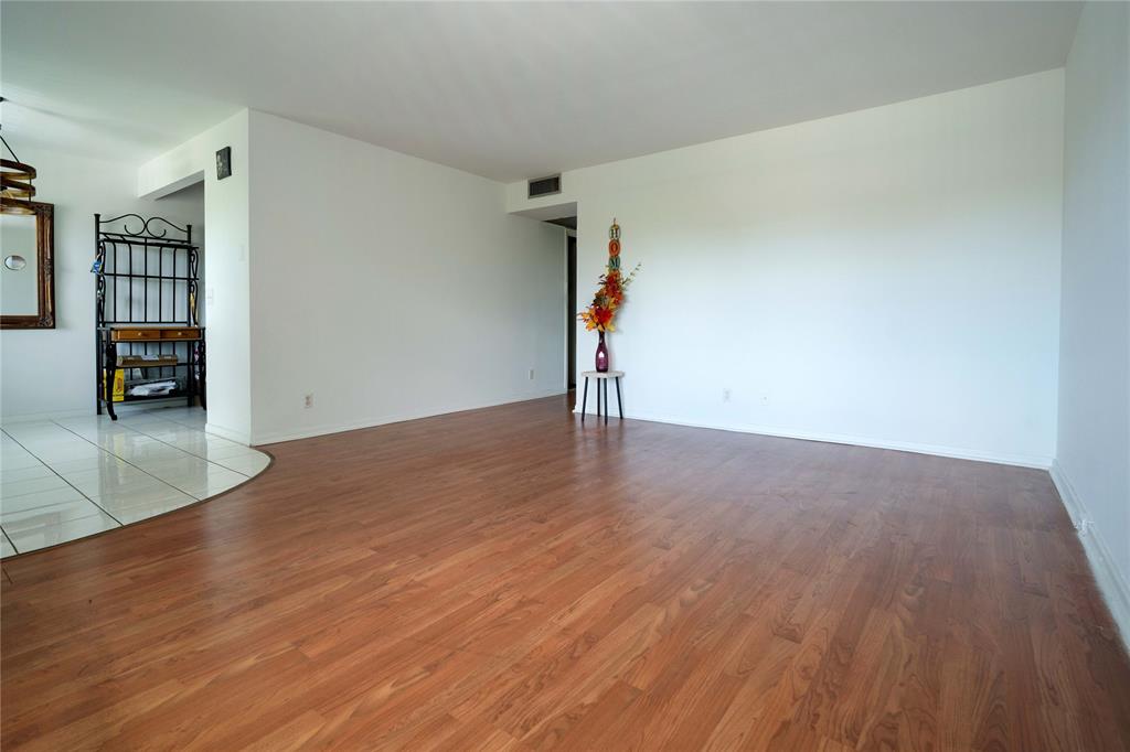 300 Southwest 134th Way, Unit 402E Pembroke Pines, FL 33027 - Photo 5 of 46 an empty room with wooden floor and a fireplace