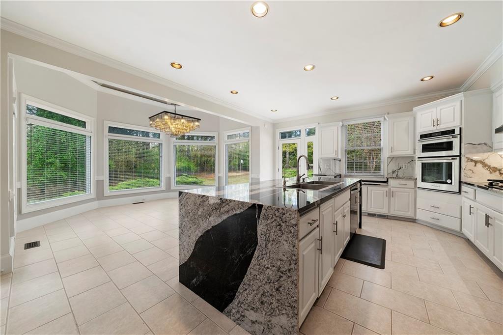 5360 Northwater Way Duluth, GA 30097 - Photo 15 of 62 a large white kitchen with granite countertop a large window and stainless steel appliances