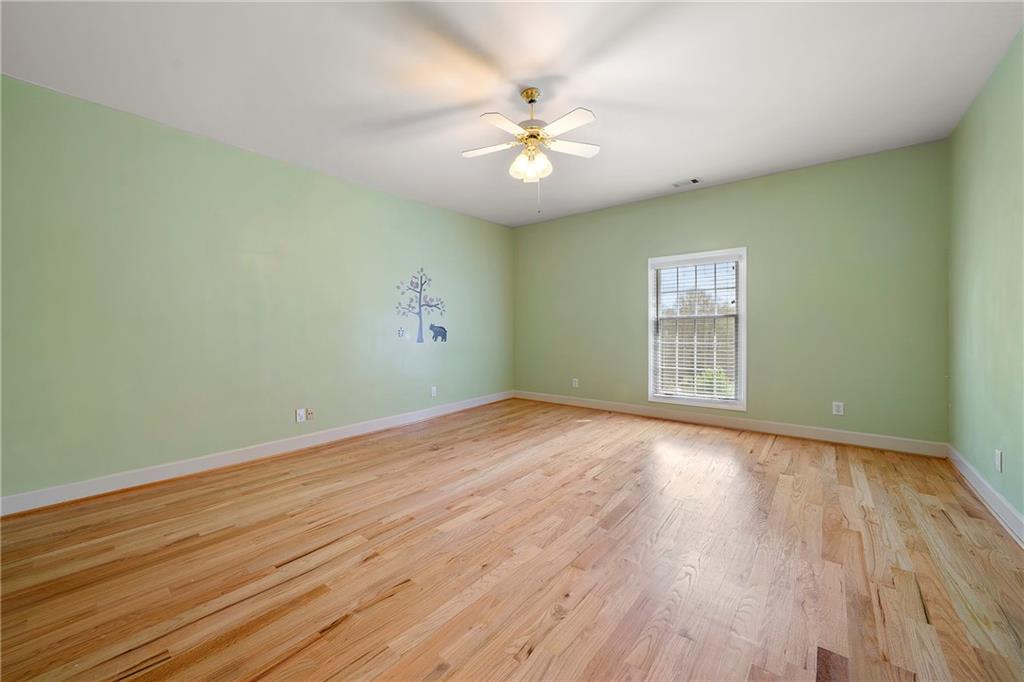 5360 Northwater Way Duluth, GA 30097 - Photo 35 of 62 an empty room with wooden floor chandelier fan and windows