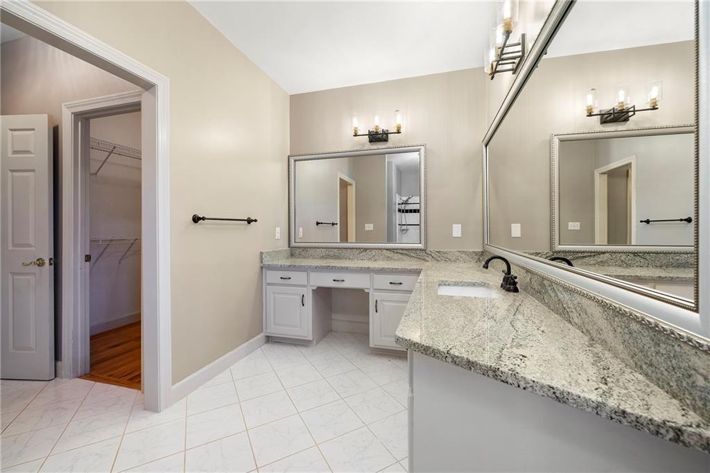 5360 Northwater Way Duluth, GA 30097 - Photo 38 of 62 a bathroom with a granite countertop sink a large mirror and a bathtub