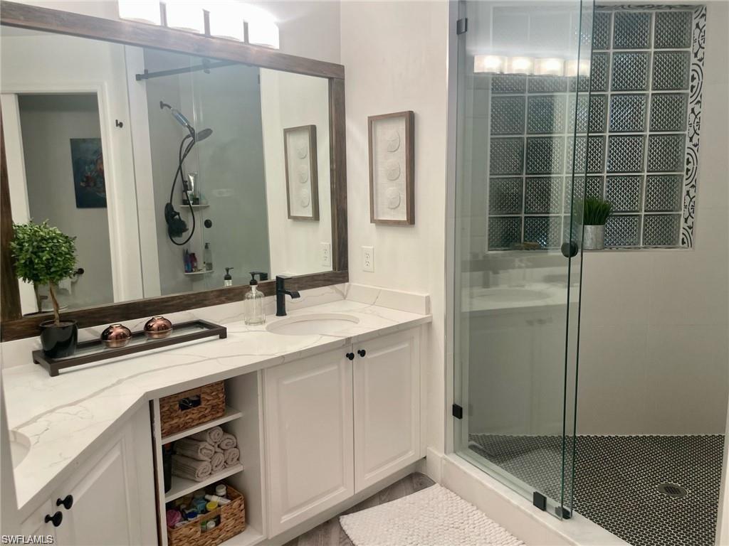56 Silver Oaks Circle, Unit 102 Naples, FL 34119 - Photo 5 of 12 Full bathroom with a stall shower and vanity