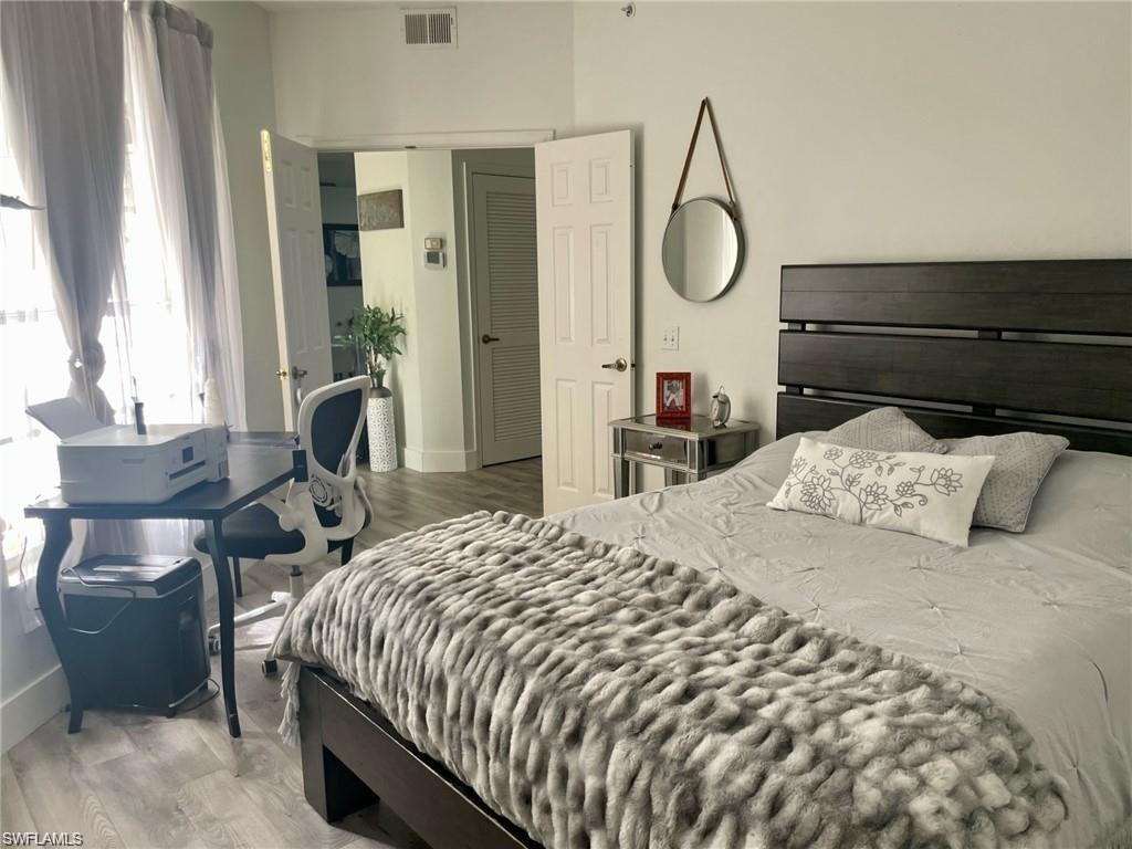 56 Silver Oaks Circle, Unit 102 Naples, FL 34119 - Photo 6 of 12 Bedroom with wood finished floors