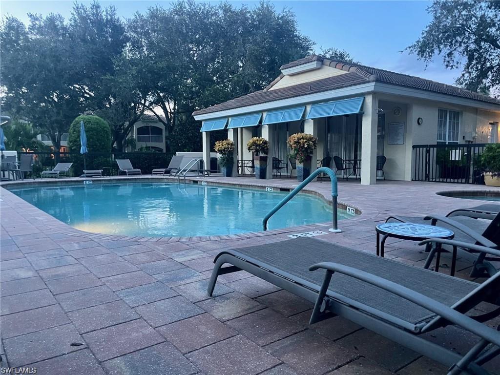 56 Silver Oaks Circle, Unit 102 Naples, FL 34119 - Photo 8 of 12 Community pool with a patio