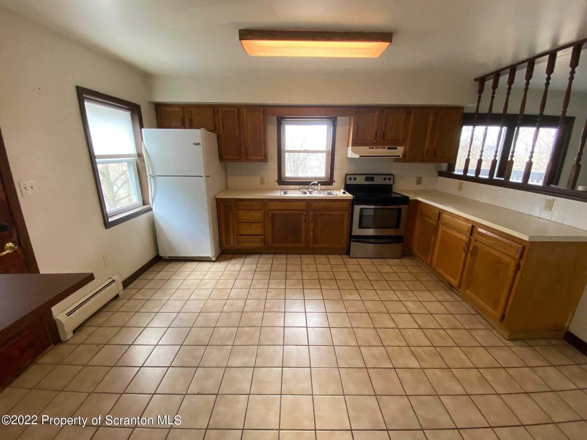 23 East Mountain Road Scranton, PA 18505 - Photo 16 of 26 a large kitchen with a stove a refrigerator and a fireplace