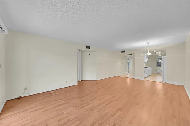 a view of a room with wooden floor and a ceiling fan