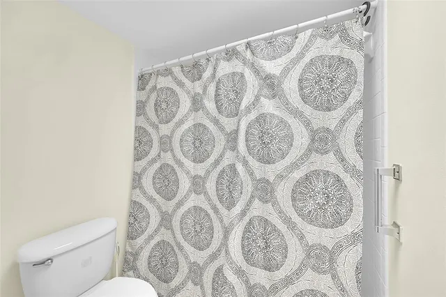 a view of a room with a large window and wooden floor