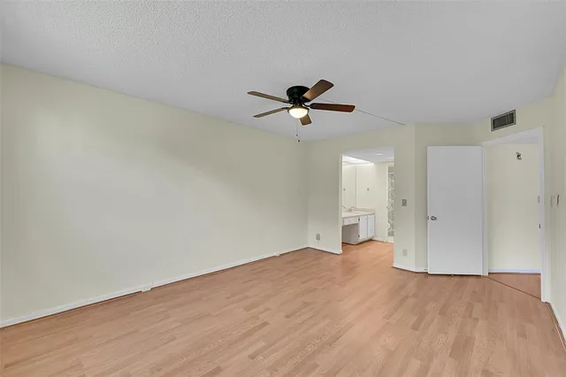 a view of a tennis ground with large trees