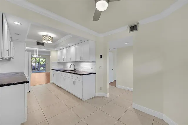 a view of a kitchen with a sink and dishwasher a stove top oven with wooden floor