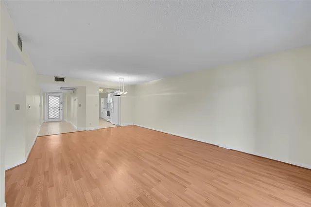a large white kitchen with a sink and dishwasher a stove top oven with white cabinets