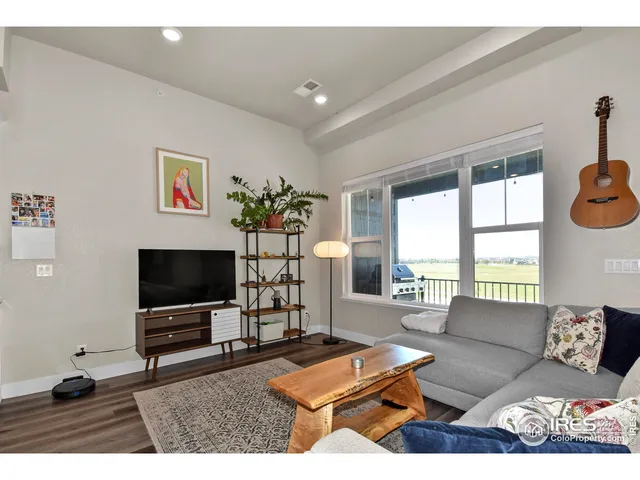 a living room with furniture a flat screen tv and a floor to ceiling window